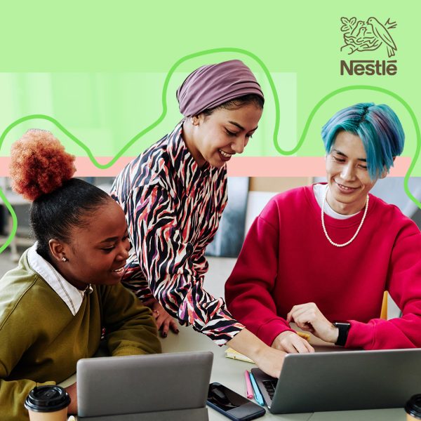 Three diverse people collaborating on an open laptop.