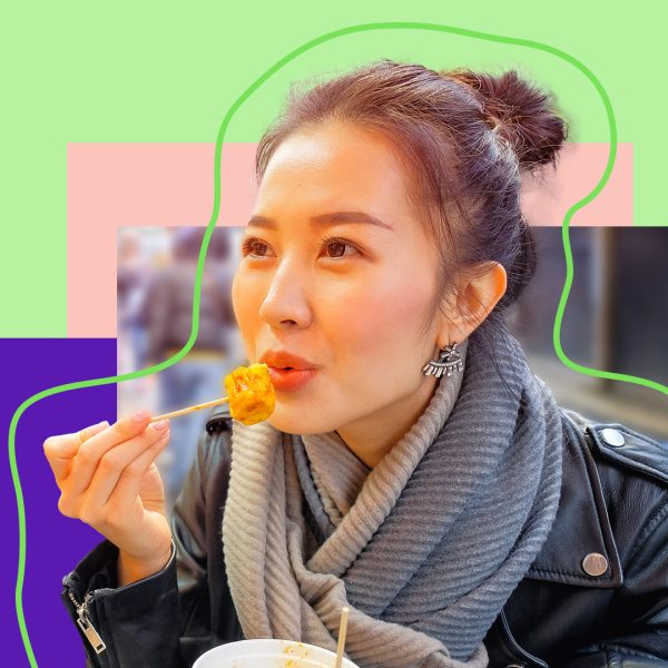 Chinese woman eating dumplings in the streets of Hong Kong